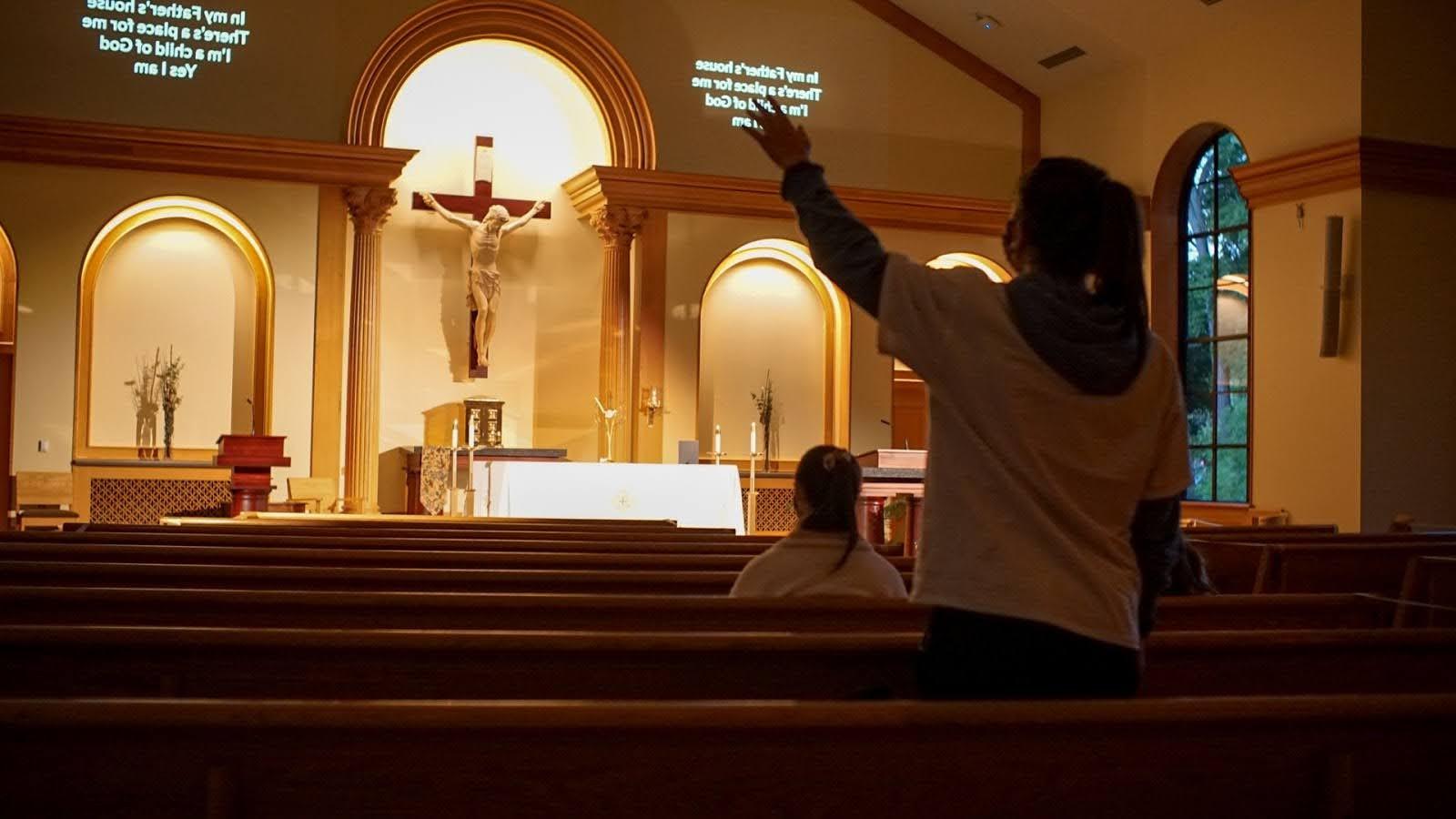 Back of student who has arm raised inside the Chapel