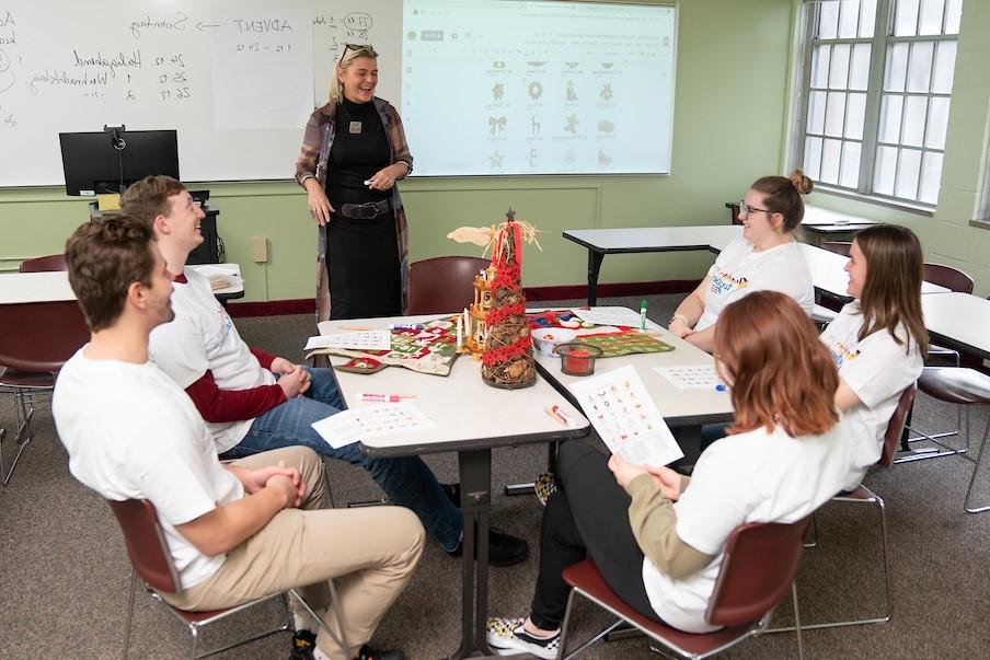 German students and professor at a desk laughing